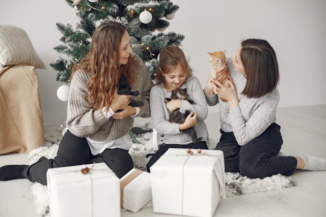 mother-with-children-with-kittens-near-christmas-tree-