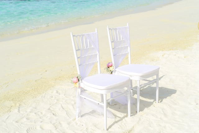 two-white-armless-chairs-on-seashore